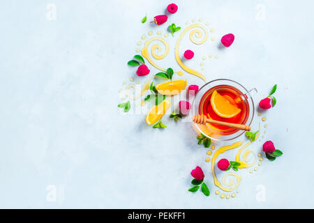 Honig Kaffee von oben. Dekorative Honig wirbelt, Zitronenscheiben, Beeren und Kaffee in einem Glas Schale auf einem weißen Holz- Hintergrund mit kopieren. Kreative foo Stockfoto