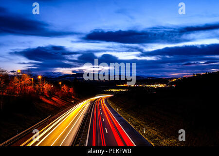 Lange Belichtung Night Shot einer Autobahn aus der Region Freiburg in der Schweiz, mit roten und gelben Fahrzeug leichte Wanderwege und der öffentlichen Beleuchtung Stockfoto