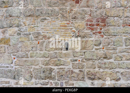 An der Wand eines alten Hauses mit Spuren von Restaurierung und andere Größe Steine Stockfoto