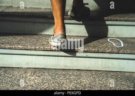 Nahaufnahme Bein geschossen von erwachsenen Mann zu Fuß die Treppe Stockfoto