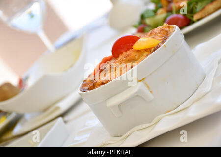 Mittelmeer Teller gebacken mit Kruste auf der Oberseite, der mit einem weißen Porzellan Teller serviert. Stockfoto