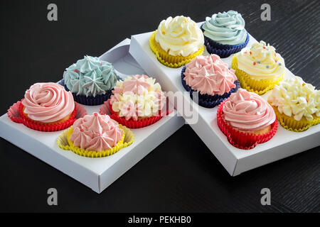 Satz von verschiedenen hausgemachten Kuchen mit buttercream in zwei der Papierausgabe. Kopieren Sie Platz. Selektive konzentrieren. Stockfoto