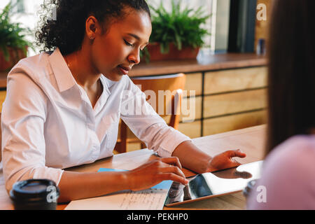 Junge Geschäftsfrau arbeiten an digitalen Tablette im Cafe Stockfoto