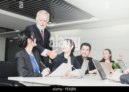 Zur Erläuterung und Diskussion über Konzept, Glücklich und Art Manager reden und loben mit Stäben mit Laptop und die Einführung seiner Partner über Manag Stockfoto