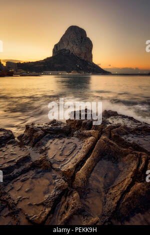 Sonnenaufgang am Strand in Calpe (Alicante, Spanien), mit Penon de Ifach Naturpark im Hintergrund. Stockfoto