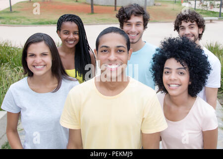 Große Gruppe von schönen jungen Männern und Frauen aus der ganzen Welt im Freien im Sommer Stockfoto