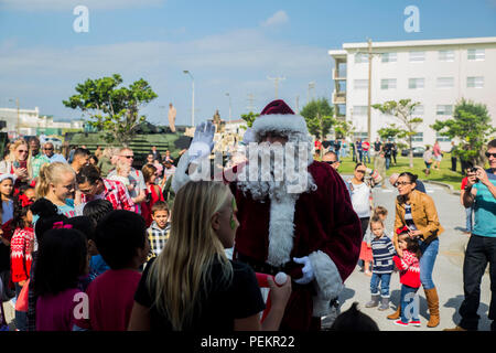 Santa Claus kommt für den Fall, Santa's Little Helper, auf Camp Hansen, Okinawa, Japan, Dez. 12, 2015. Die Veranstaltung hatte auch der Weihnachtsmann schnell Seil aus einem Hubschrauber, Kunstschnee, eine Hüpfburg, Kinderschminken und Essen serviert. Wurde die Veranstaltung durch Kampf Angriff Bataillon, 3rd Marine Division, III Marine Expeditionary Force und Marine Corps Community Services. (U.S. Marine Corps Foto von Cpl. Tyler S. Giguere/Freigegeben) Stockfoto