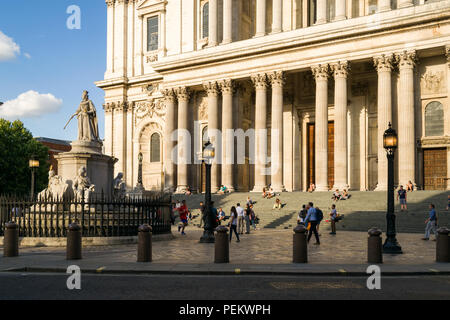 Blick auf den Westen Portikus der St. Paul's Kathedrale von St. Paul Kirchhof Straße mit Menschen setzte sich auf Schritte und vorbei an einem sonnigen Abend Stockfoto