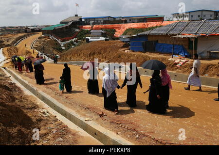 Cox's Bazar, Bangladesch. Rohingya Flüchtlinge Frauen gesehen gehen an einem Flüchtlingslager in Ukhia, Cox's Bazar, Bangladesch am 3. August 2018. Monsunregen verursachen Überschwemmungen Erdrutsche in den weltweit größten Flüchtlingslager in Bangladesch, wo mehr als eine Million Menschen, die Rohingya in Bambus und plane Blatt Unterständen. Über eine halbe Million Rohingya Flüchtlinge aus Myanmar Rakhine, haben in Bangladesch seit dem 25. August 2017 flohen nach Angaben der Vereinten Nationen. Der Myanmar militärische Kampagne gegen die Rohingyas begann nach dem Angriff auf mehrere Polizei Beiträge in Rakhine. Stockfoto