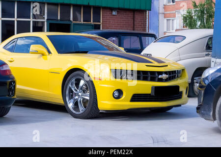 Nowosibirsk, Russland - 07.06.2018: Chevrolet Camaro gelb mit schwarzen Streifen auf der Motorhaube und Chrom Räder aus Gusseisen in Form einer Hummel autobot tra Stockfoto