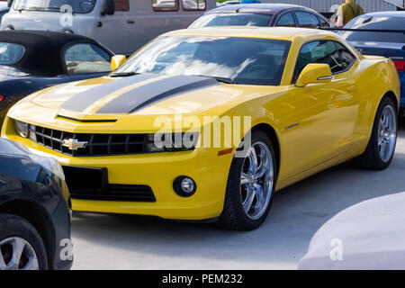 Nowosibirsk, Russland - 07.06.2018: Chevrolet Camaro gelb mit schwarzen Streifen auf der Motorhaube und Chrom Räder aus Gusseisen in Form einer Hummel autobot tra Stockfoto