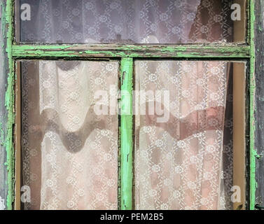 Alten hölzernen Fensterrahmen mit Peeling grün Lack, Farben und Schatten an einem sonnigen Tag Stockfoto