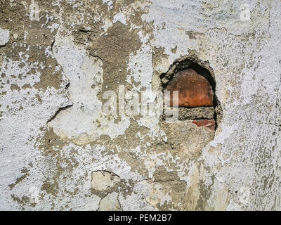 Textur, Hintergrund der Vintage alte weiß getünchten Wand mit beschädigten geschält Putz und eine Grunge aus rotem Backstein. Stockfoto