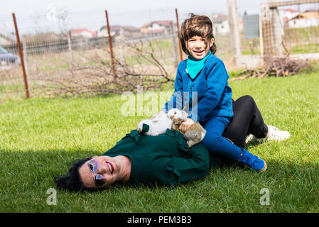 Mutter und Sohn gemeinsam Spaß im Garten mit kleine Hasen Stockfoto