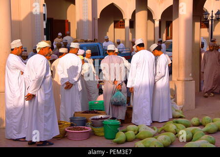 NIZWA, OMAN - Februar 3, 2012: Omani Männer traditionell gekleidete Versammlung in einer lokalen Gemüsemarkt in Nizwa Altstadt Stockfoto