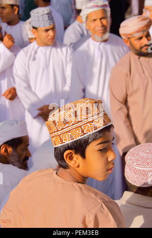 NIZWA, OMAN - Februar 3, 2012: Omani Männer traditionell gekleidete Teilnahme an der Ziege Markt mit einem kleinen Jungen im Vordergrund. Stockfoto