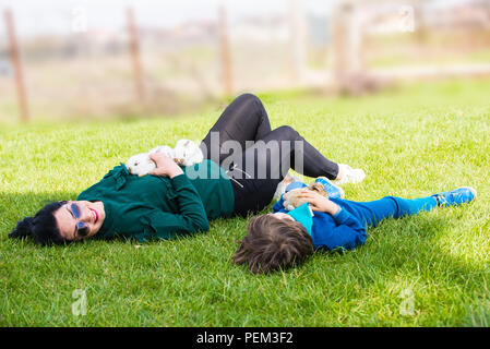 Mutter und Sohn Festlegung auf Gras und kleine Kaninchen Stockfoto