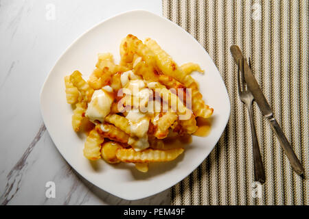 Kanadische Poutine crinkle - schneiden Pommes mit Soße und Käse Quark Stockfoto