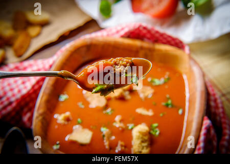 Frische Hot Tomate Basilikum Suppe mit Croutons in dunklen stimmungsvolle Beleuchtung Stockfoto
