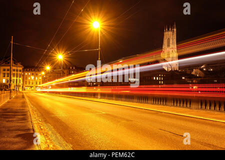 Lange Belichtung Night Shot der Stadt Freiburg in der Schweiz, mit Fahrzeug leichte Wanderwege auf der Seite und der Kathedrale Saint-Nicolas auf der Rückseite Stockfoto