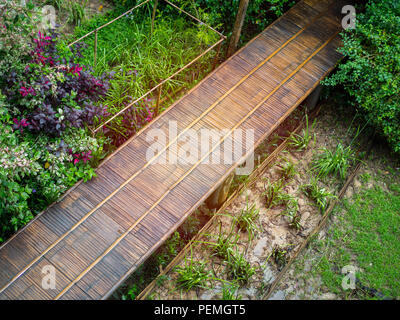 Holzbrücke Gehweg. Bamboo Brücke mit Baum und Blume Park und Paddy Ansicht von oben. Stockfoto