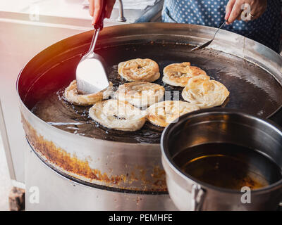 Gebratene indisches Brot Roti im großen Topf. Hände die traditionelle indische Küche. Roti Öl. Stockfoto