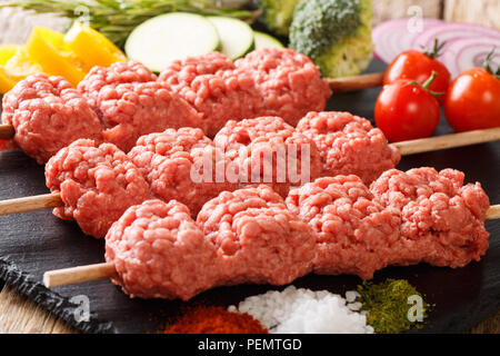 Raw kebab Rinderhackfleisch mit Zutaten und Gemüse close-up auf dem Tisch. Horizontale Stockfoto