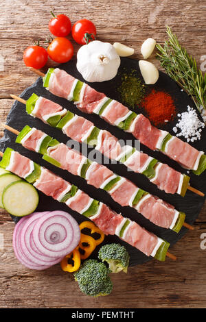 Für Grill rohe Shish Kebab mit Pfeffer und Schmalz auf Spieße close-up und Zutaten, Gemüse, Gewürze, Kräuter auf dem Tisch. Vertikal oben Blick von Stockfoto