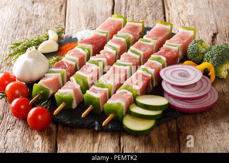 Nahaufnahme von Spieße mit saftigen Fleisch und Gemüse. Raw Kebab aus Schweinefleisch. Horizontale, rustikal Stockfoto