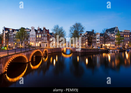 Kanäle von Amsterdam in der Nacht. Amsterdam ist die Hauptstadt und die bevölkerungsreichste Stadt der Niederlande. Stockfoto