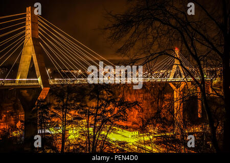 Lange Belichtung Night Shot von poyabrücke, in die Stadt Freiburg in der Schweiz, mit Fahrzeug leichte Wanderwege und öffentliche Beleuchtung, Bäume im Vordergrund. Stockfoto