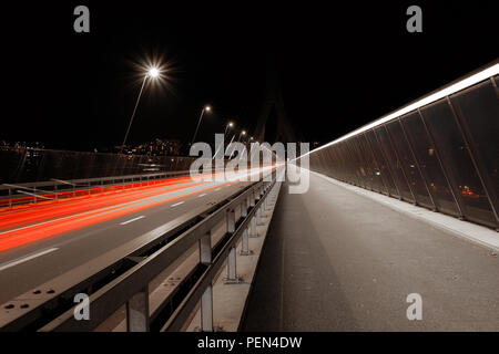 Lange Belichtung Night Shot von poyabrücke, in die Stadt Freiburg in der Schweiz, mit roten Fahrzeug leichte Wanderwege und der öffentlichen Beleuchtung Stockfoto