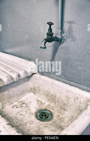 Alte vintage Waschbecken mit Kupfer Wasserhahn und ein grauer Hintergrund Stockfoto