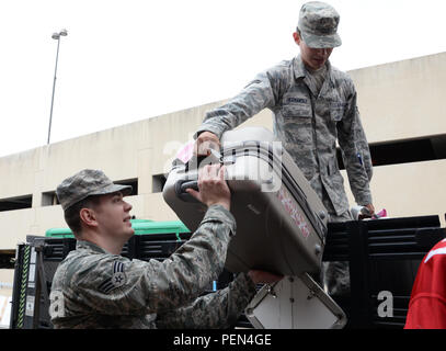 Us Air Force Senior Airman Joshua Simpson, ein logistiker auf der 136 Logistik Bereitschaft Squadron, Texas Air National Guard zugewiesen, und die Flieger 1. Klasse Valentin Hernandez, ein Sicherheitskräfte Lehrling an die 301 Sicherheitskräfte Squadron zugeordnet, von der Naval Air Station Fort Worth gemeinsame Reserve Base, Texas, Gepäck für Teilnehmer von Snowball Express 2015 in Dallas - Fort Worth Flughafen, Dez. 12, 2015 entladen. Snowball Express ist eine Organisation, die Kinder der militärischen Mitglieder, die während der Active Duty seit Sept. 11 gestorben sind. (Air National Guard Foto von Tech. Sgt. Van Stockfoto