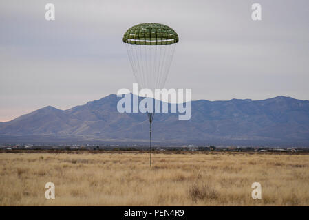 Ein freistehendes cargo Extraktion Fallschirm landet in einem Feld nach dem Extrahieren ein Humvee von der US Air Force HC-130J Bekämpfung King II, ab dem 79. Rescue Squadron, während die 563 antenne Lieferung d Operations Support Squadron und Extraktion Training in Fort Huachuca, Ariz., Dez. 9, 2015. Dieses Training war das erste Mal, dass die Rettungsmaßnahmen squadron verpackt und ein schweres Fahrzeug ohne externe Hilfe und das erste Mal ein schweres Fahrzeug durch die 79 RQS fallengelassen wurde manipuliert. (U.S. Air Force Foto von älteren Flieger Chris Massey/Freigegeben) Stockfoto