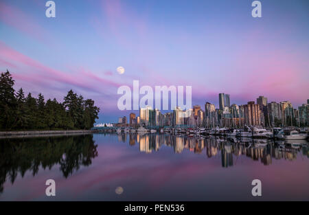 Mond über der Innenstadt von Vancouver bei Sonnenuntergang vom Stanley Park. Stockfoto