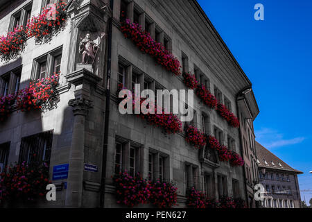 Landschaft Blick auf ein traditionelles Gebäude aus dem grand-rue Straße von Freiburg, in der Schweiz, mit Blumen auf jedem Windows Stockfoto