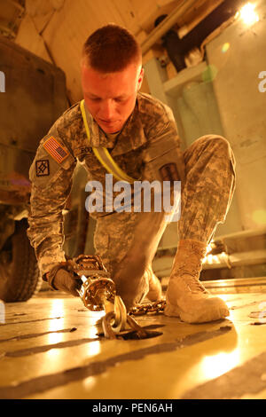 Ein Michigan Army National Scots Guards auf die 1 Mrd. zugewiesen., 182Th FA Regt., Ausrüstung auf dem Deck eines Lockheed C-5 Galaxy sichert für einen Gurt Luftbrücke nach US Central Command Dez. 3 Silas L. Copeland Ankunft/Abflug Air Control Gruppe Flugplatz hier. Stockfoto