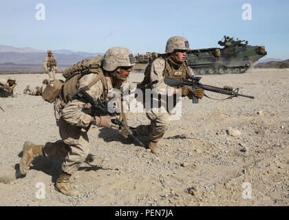 Marines rush eine simulierte Bekämpfung der Stadt während der mechanisierten Angriff Teil des Marine Corps Combat Readiness Übung in Marine Corps Air Ground Combat Center Twentynine Palms, Calif., Dez. 9, 2015. Der Zweck einer MCCRE ist Marines "kollektive Leistung in spezifische Mission, Anforderungen, die Sie für Ihre bevorstehenden Bereitstellung rotation vorbereiten, zu bewerten. Die Marines sind mit 2Nd Battalion, 7th Marine Regiment, 1st Marine Division. (U.S. Marine Corps Foto von Lance Cpl. Devan K. Gowans) Stockfoto