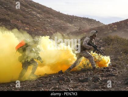 Marines laufen durch die Verstopfung von Rauch während der Unternehmen unterstützt, live - Feuer Angriff Teil des Marine Corps Combat Readiness Bewertung beim Marine Corps Air Ground Combat Center Twentynine Palms, Calif., Dez. 6, 2015. Der Zweck einer MCCRE ist Marines "kollektive Leistung in spezifische Mission, Anforderungen, die Sie für Ihre bevorstehenden Bereitstellung rotation vorbereiten, zu bewerten. Die Marines sind mit 2Nd Battalion, 7th Marine Regiment, 1st Marine Division. (U.S. Marine Corps Foto von Lance Cpl. Devan K. Gowans) Stockfoto