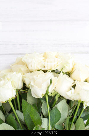 Weiße Rosen auf einem weißen Holz- Hintergrund. Blumenstrauß aus den weißen Rosen Stockfoto