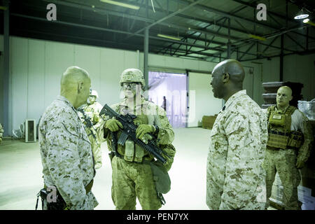 Us Marine Gen. Robert B. Neller, 37th Kommandant des Marine Corps und Sgt. Maj. Ronald Green, 18 Sergeant Major des Marine Corps, sprechen mit US Marine Cpl. Michael Ries, einer internen Threat Mitigation team leader mit Firma B, 1st Battalion, 7th Marine Regiment, Special Purpose Marine Air Ground Task Force - Krisenmanagement - Central Command und Task Force Al Taqaddum im Al Taqaddum, Irak, Dez. 21, 2015. Während ihres Besuchs in der US Central Command Verantwortungsbereich, die Staats- und Regierungschefs angesprochen Marinesoldaten und Matrosen in Fragen, die die Zukunft der Korps und wünschte ihnen ein Stockfoto