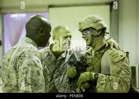 Us Marine Gen. Robert B. Neller, 37th Kommandant des Marine Corps und Sgt. Maj. Ronald Green, 18 Sergeant Major des Marine Corps, sprechen mit US Marine Cpl. Michael Ries, einer internen Threat Mitigation team leader mit Firma B, 1st Battalion, 7th Marine Regiment, Special Purpose Marine Air Ground Task Force - Krisenmanagement - Central Command und Task Force Al Taqaddum im Al Taqaddum, Irak, Dez. 21, 2015. Während ihres Besuchs in der US Central Command Verantwortungsbereich, die Staats- und Regierungschefs angesprochen Marinesoldaten und Matrosen in Fragen, die die Zukunft der Korps und wünschte ihnen ein Stockfoto