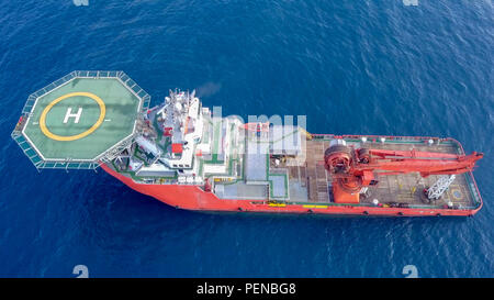 Luftbild von eine Mittelgroße rote Offshore Supply Schiff mit einem Hubschrauberlandeplatz und einem großen Kran Stockfoto