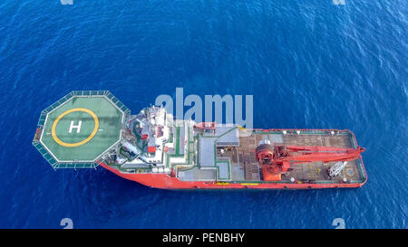 Luftbild von eine Mittelgroße rote Offshore Supply Schiff mit einem Hubschrauberlandeplatz und einem großen Kran Stockfoto