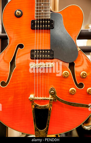 Detail einer E-Gitarre im klassischen Stil, mit Farbe und wird orange, und golden Detail Stockfoto