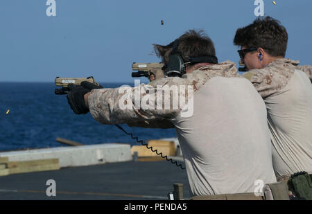 Ein U.S. Marine mit dem Force Reconnaissance Detachment, Maritime RAID Force, 26th Marine Expeditionary Unit, führt am 5. Januar 2016 an Bord des amphibischen Transportdocks USS Arlington (LPD-24) im Golf von Oman ein Training mit Live-Feuer durch. Bei dieser Übung werden Pistolen auf stationäre Ziele abgefeuert, um die Geschicklichkeit und die Bereitschaft zu wahren. Die 26. MEU wird zusammen mit der Kearsarge Amphibious Ready Group eingesetzt, um die Operationen der 5. US-Flotte zu unterstützen, um die regionale Sicherheit und Einsatzbereitschaft zu gewährleisten. Stockfoto