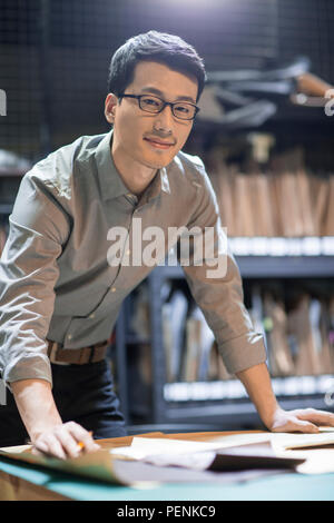 Zuversichtlich leder Handwerker Zeichnung Skizze im Studio Stockfoto