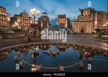 Brunnen in Platz der Unabhängigkeit in Kiew mit Lyadsky tor Globus Mall und Kozatskiy Hotel in der blauen Stunde Stockfoto