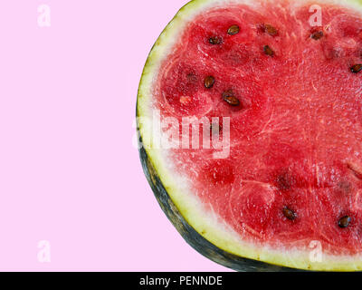 Blick von oben auf eine Nahaufnahme eines ganzen Reife saftige frische Wassermelone auf einem violetten Hintergrund Stockfoto